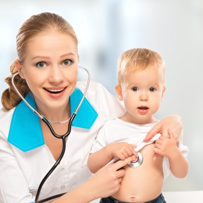 baby at the doctor pediatrician. doctor listens to the heart with a stethoscope